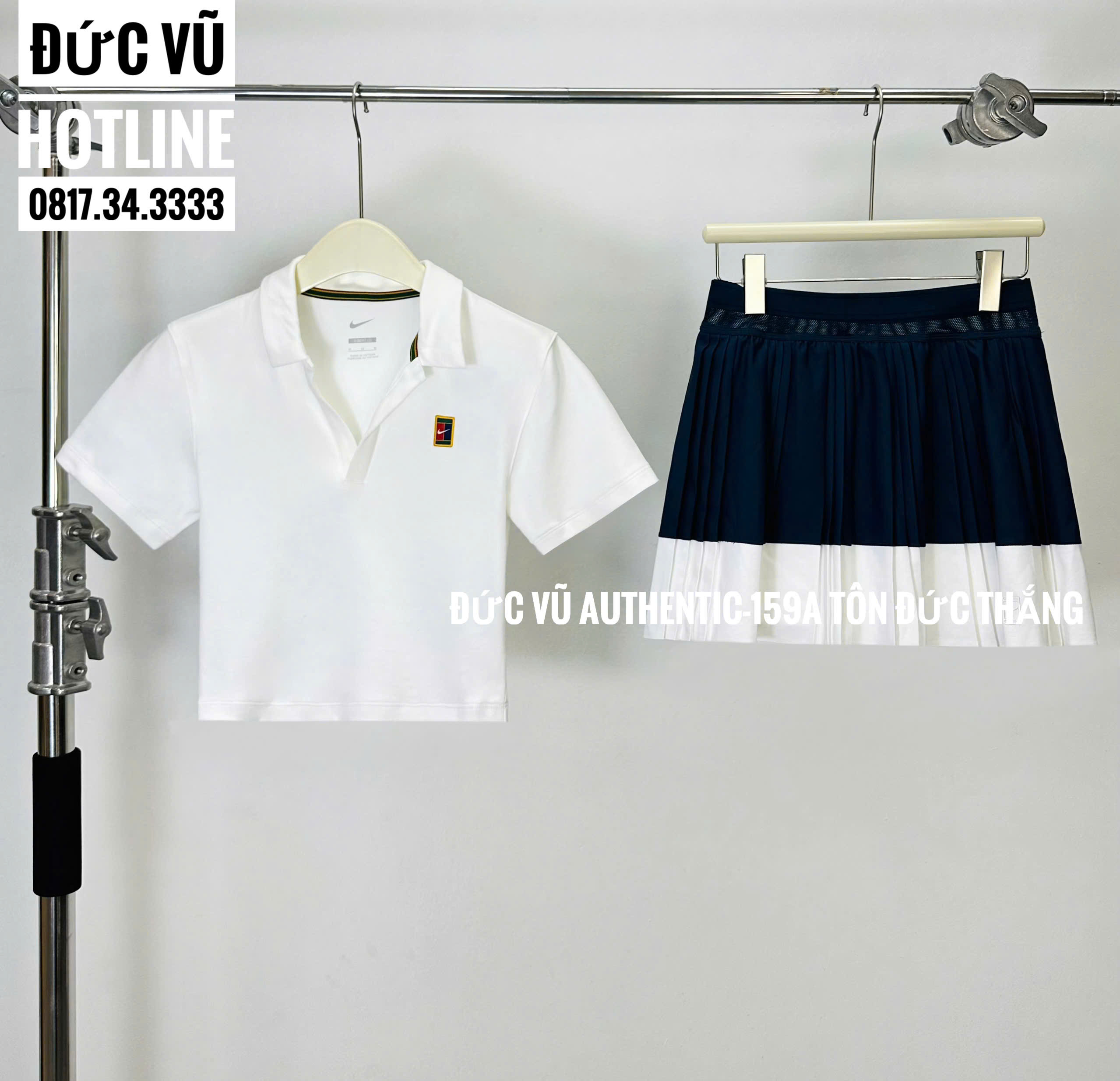 Set tennis nữ Nike – Áo polo trắng & chân váy xếp ly xanh navy viền trắng